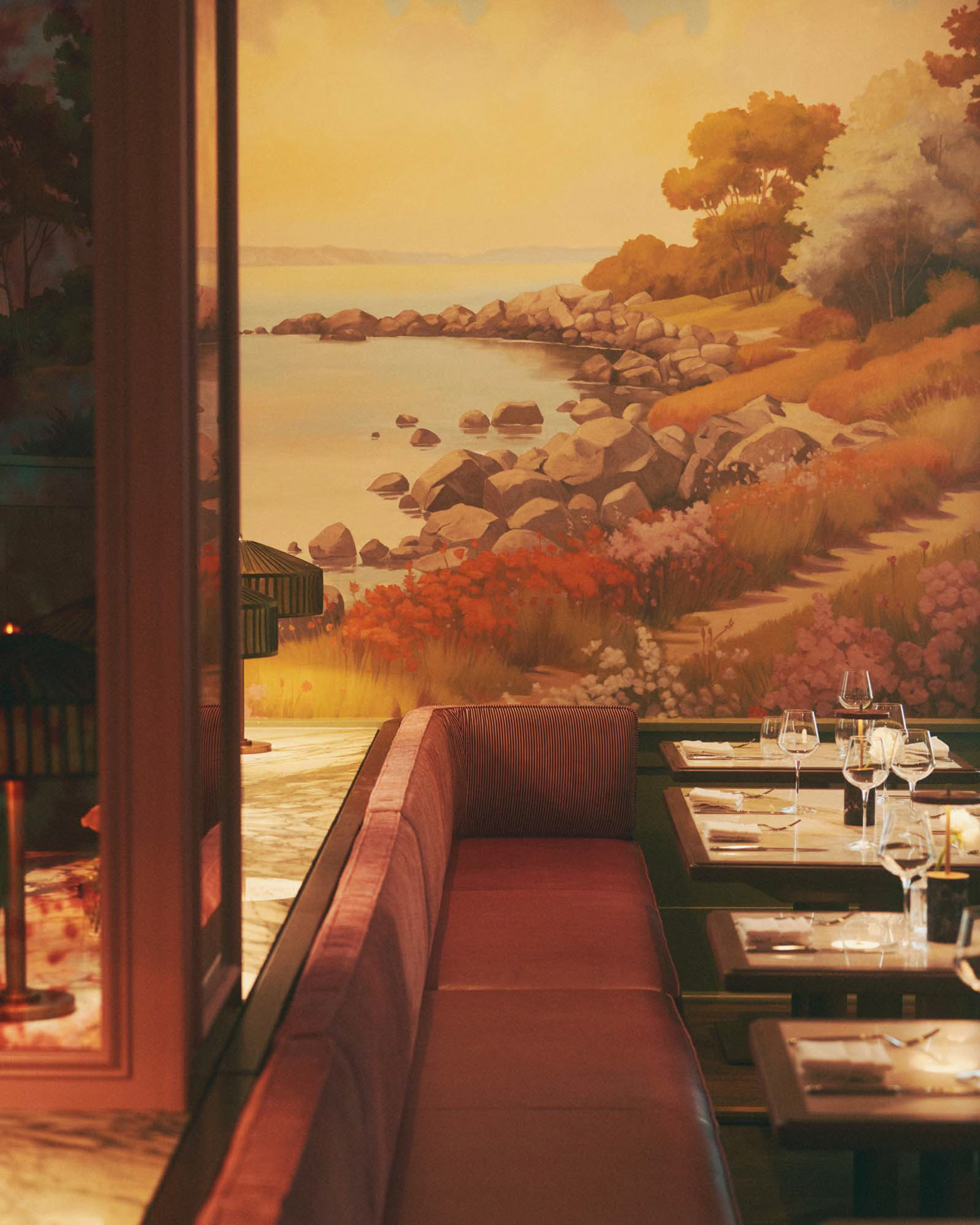 a restaurant with a wall mural of a landscape