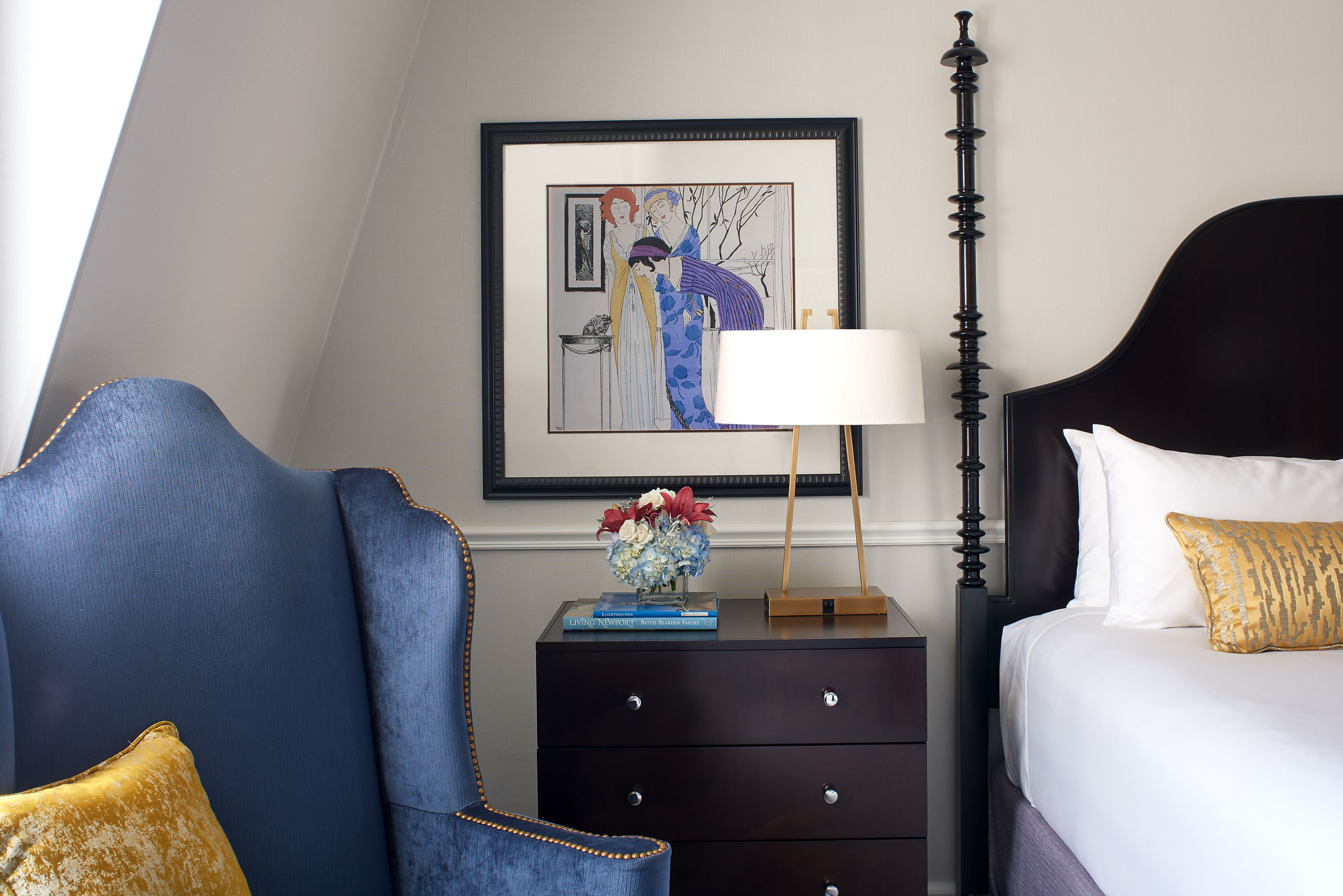 a bedroom with a painting and a lamp