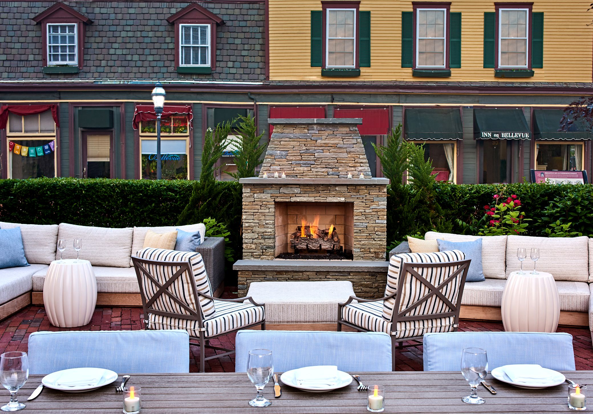 a patio with a fireplace and chairs