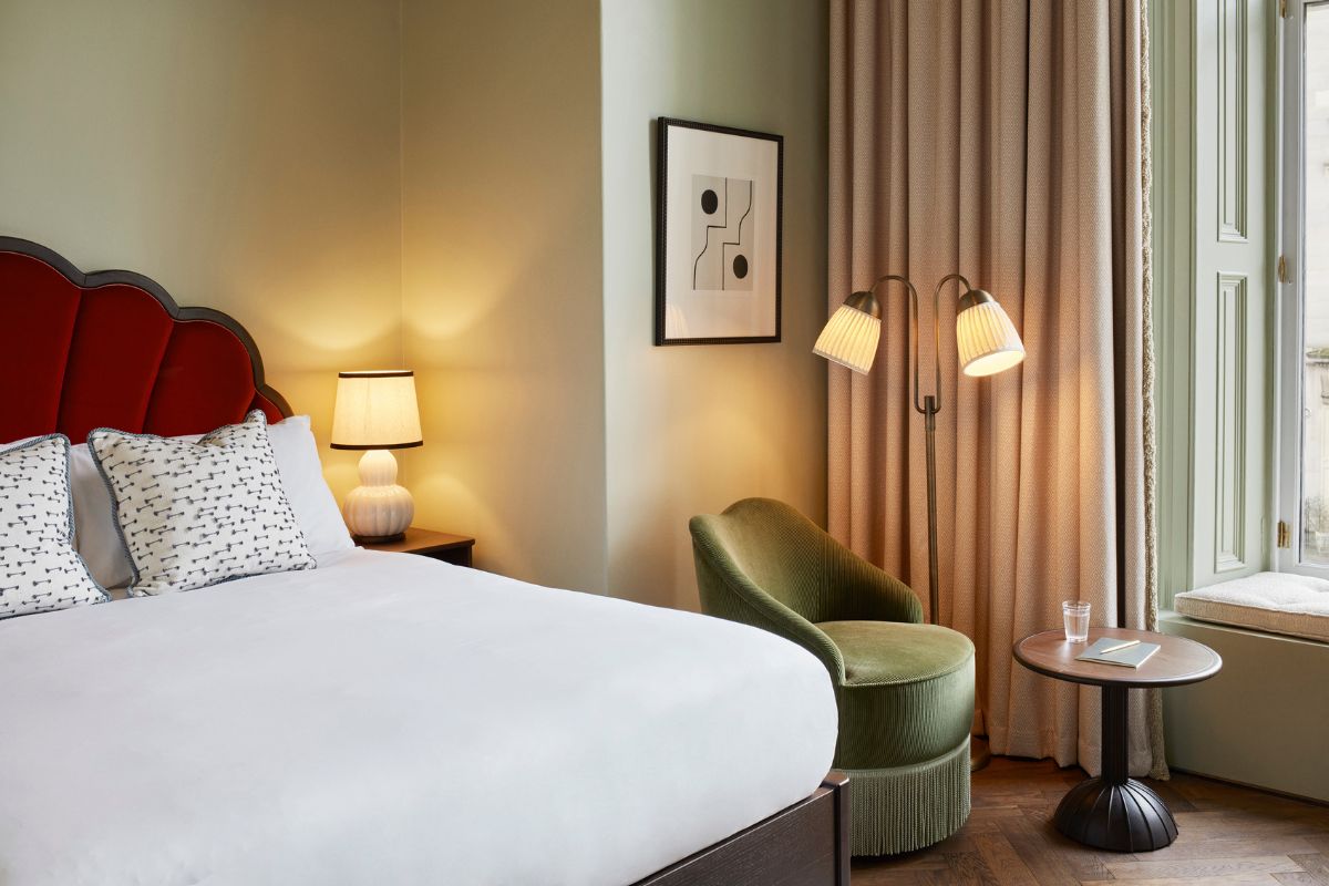 a bed with a chair and a table in a room