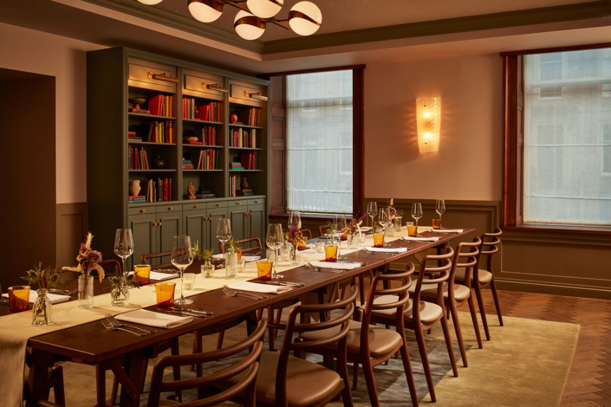 a long table with wine glasses and chairs in a room