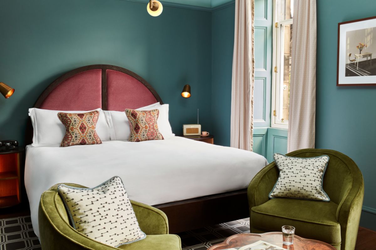 a bedroom with a bed and chairs
