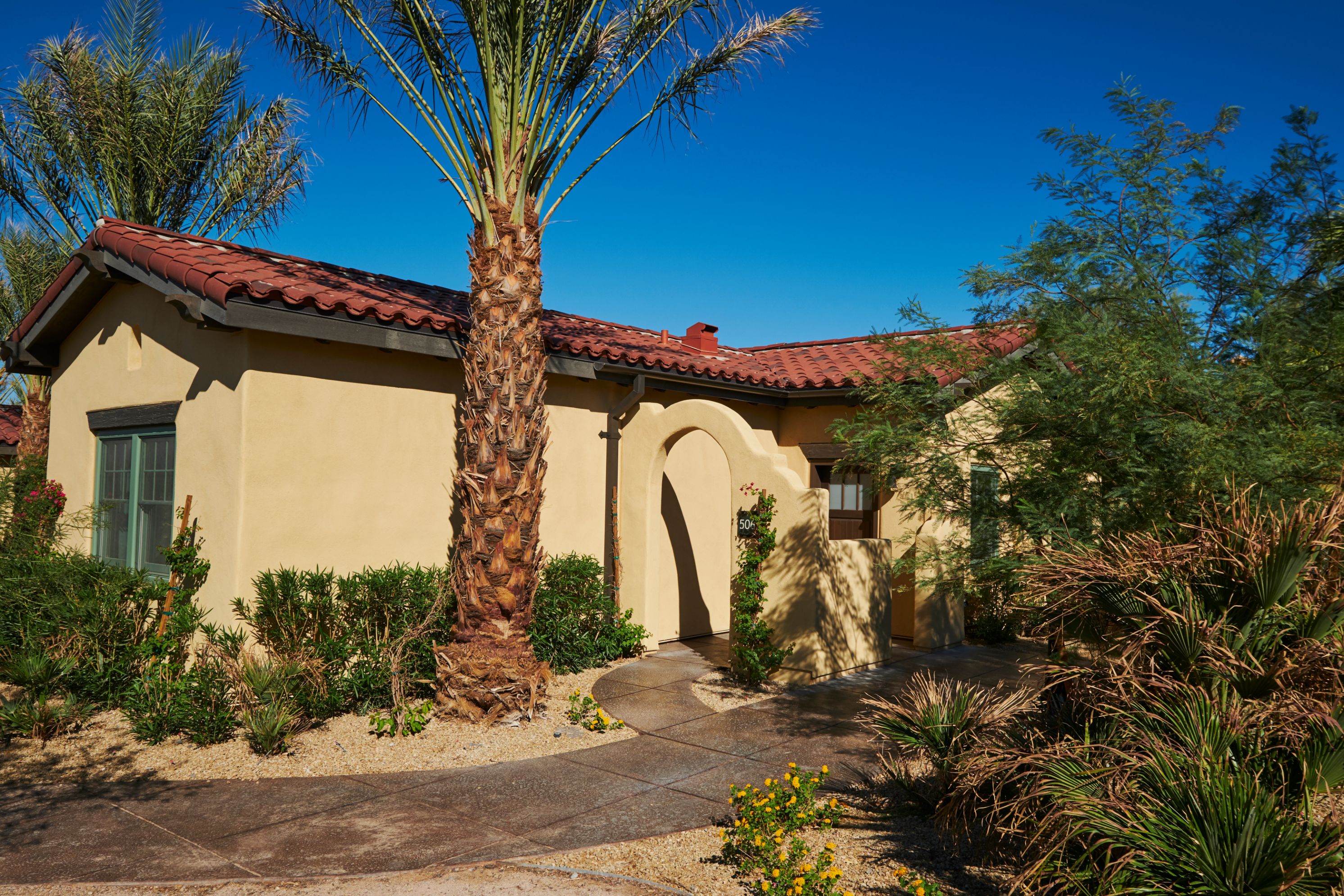 a house with palm trees and a walkway