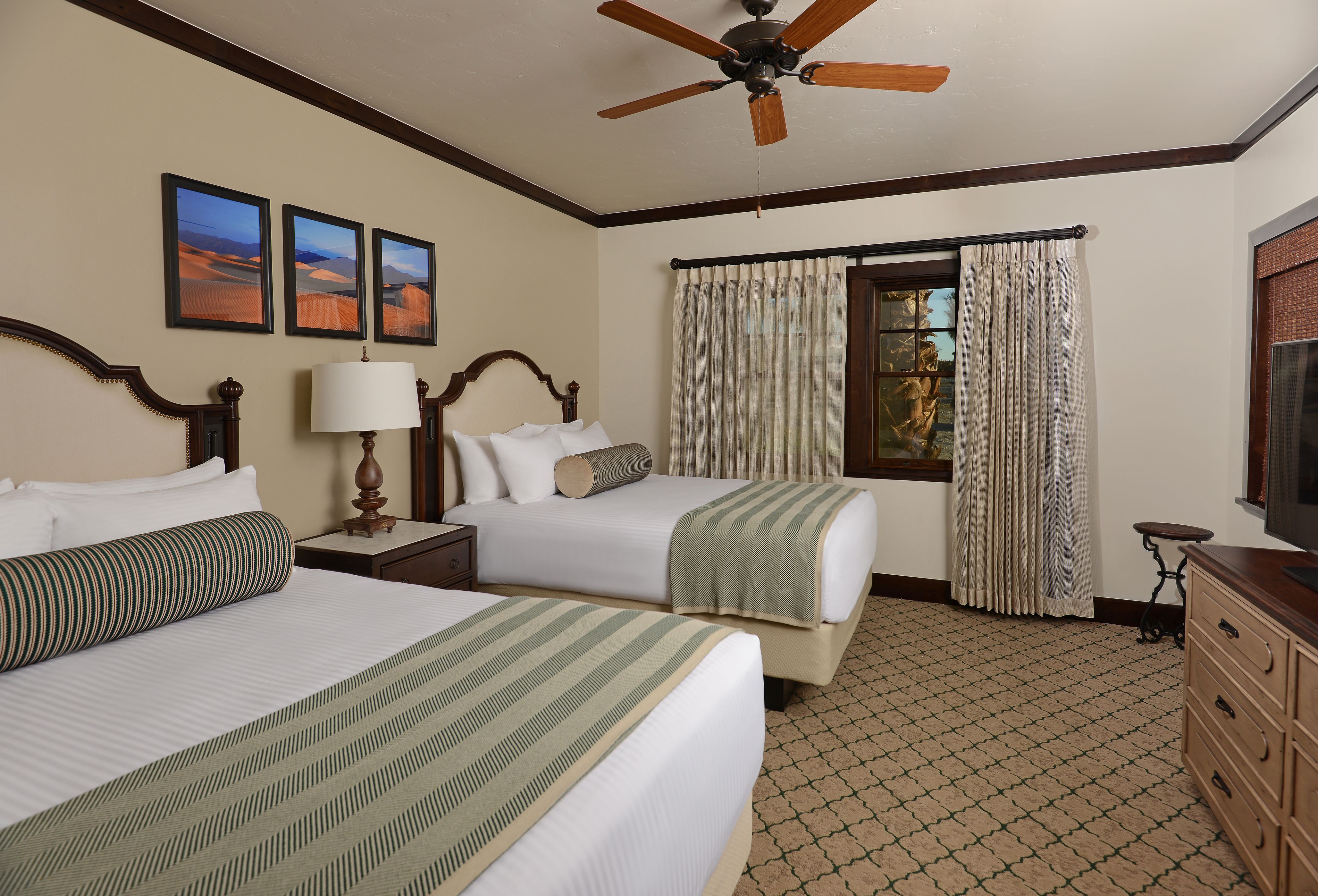 a room with two beds and a ceiling fan