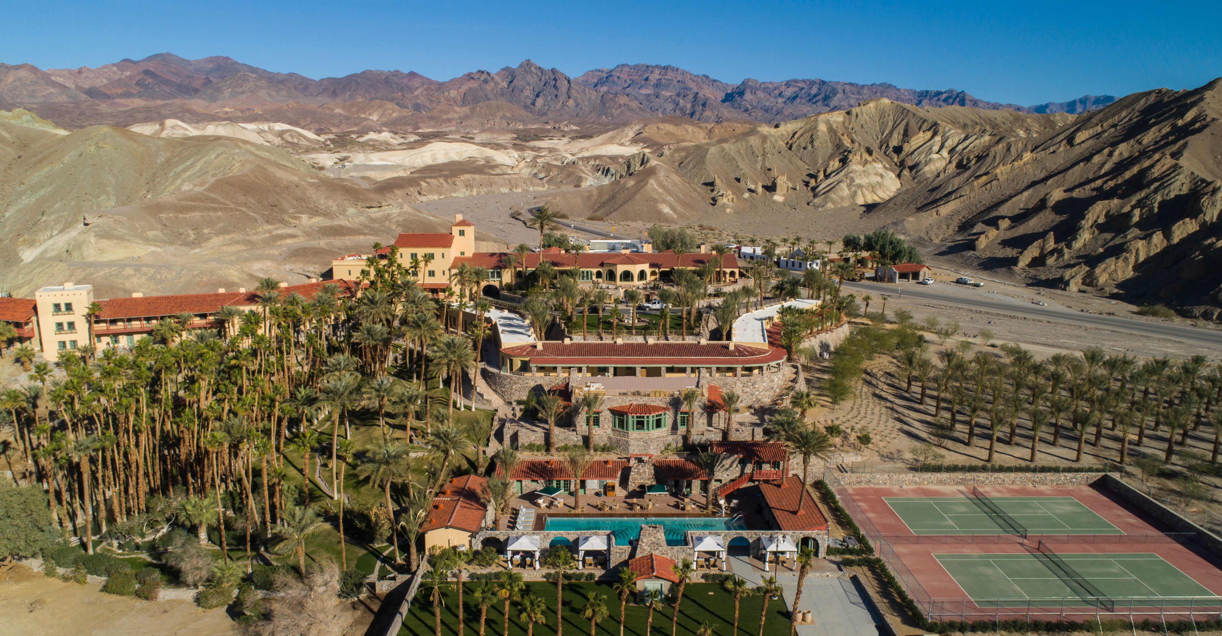 a resort with palm trees and tennis court