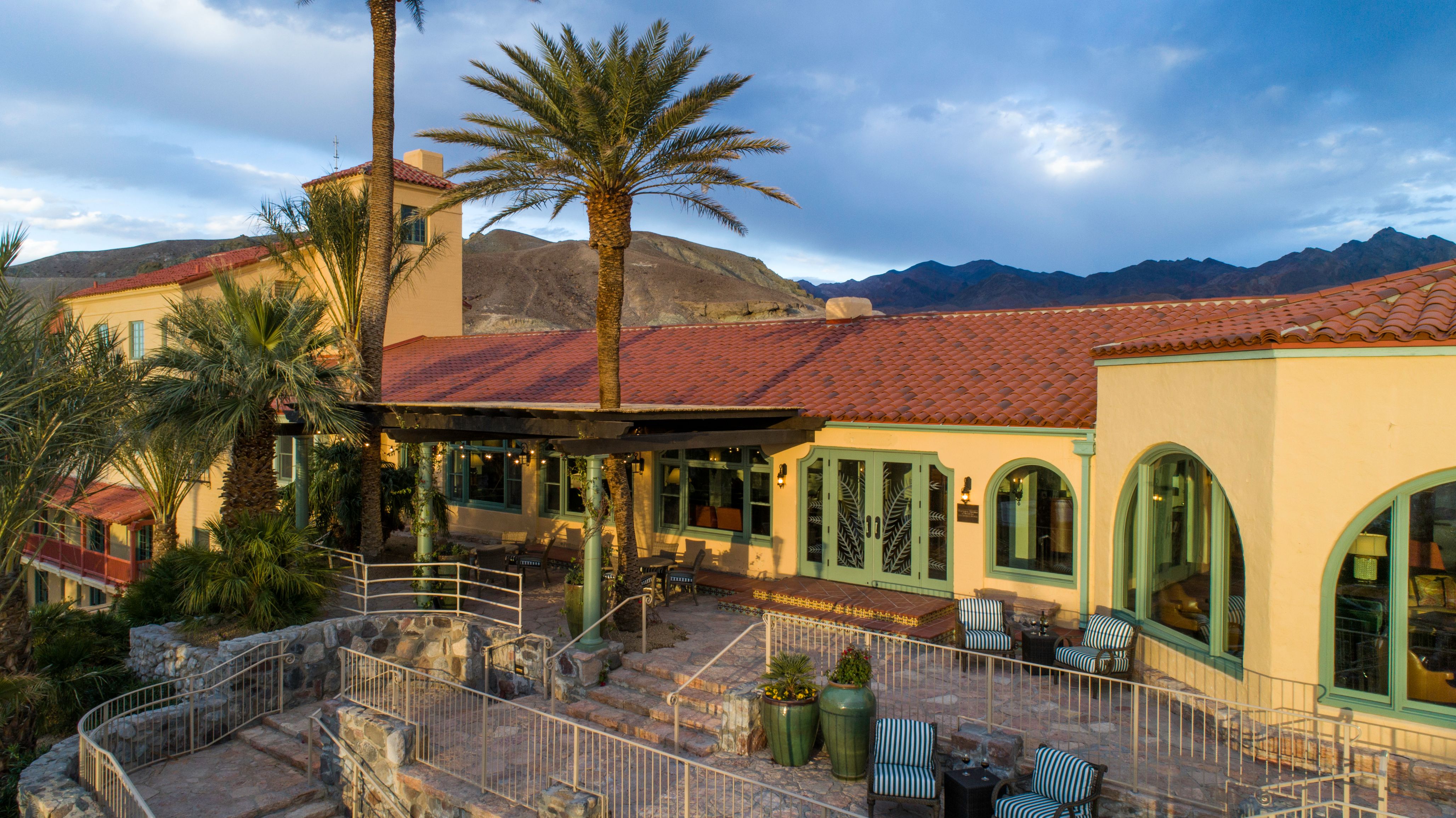 a building with palm trees and a stone walkway