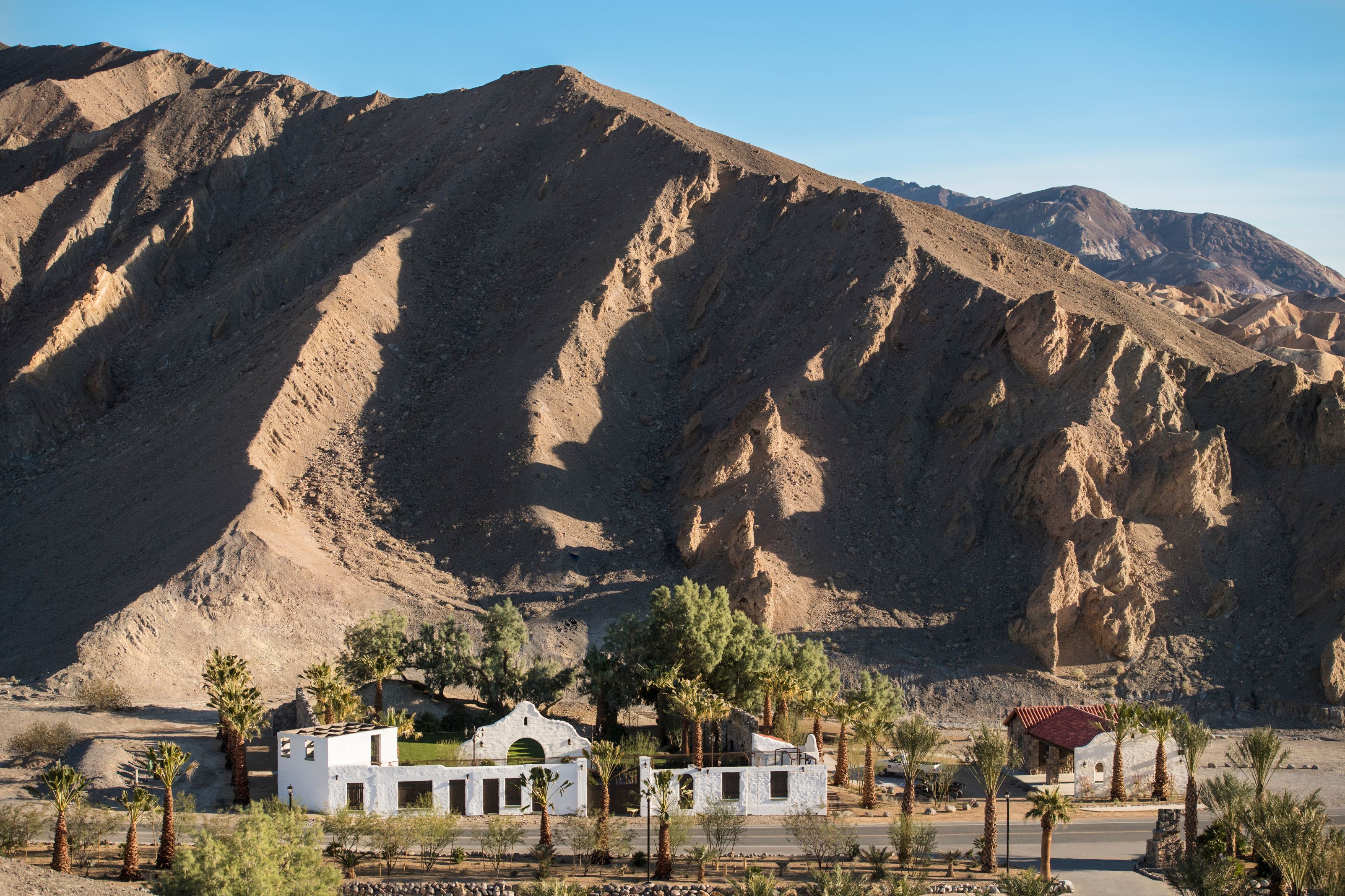 a white building next to a mountain