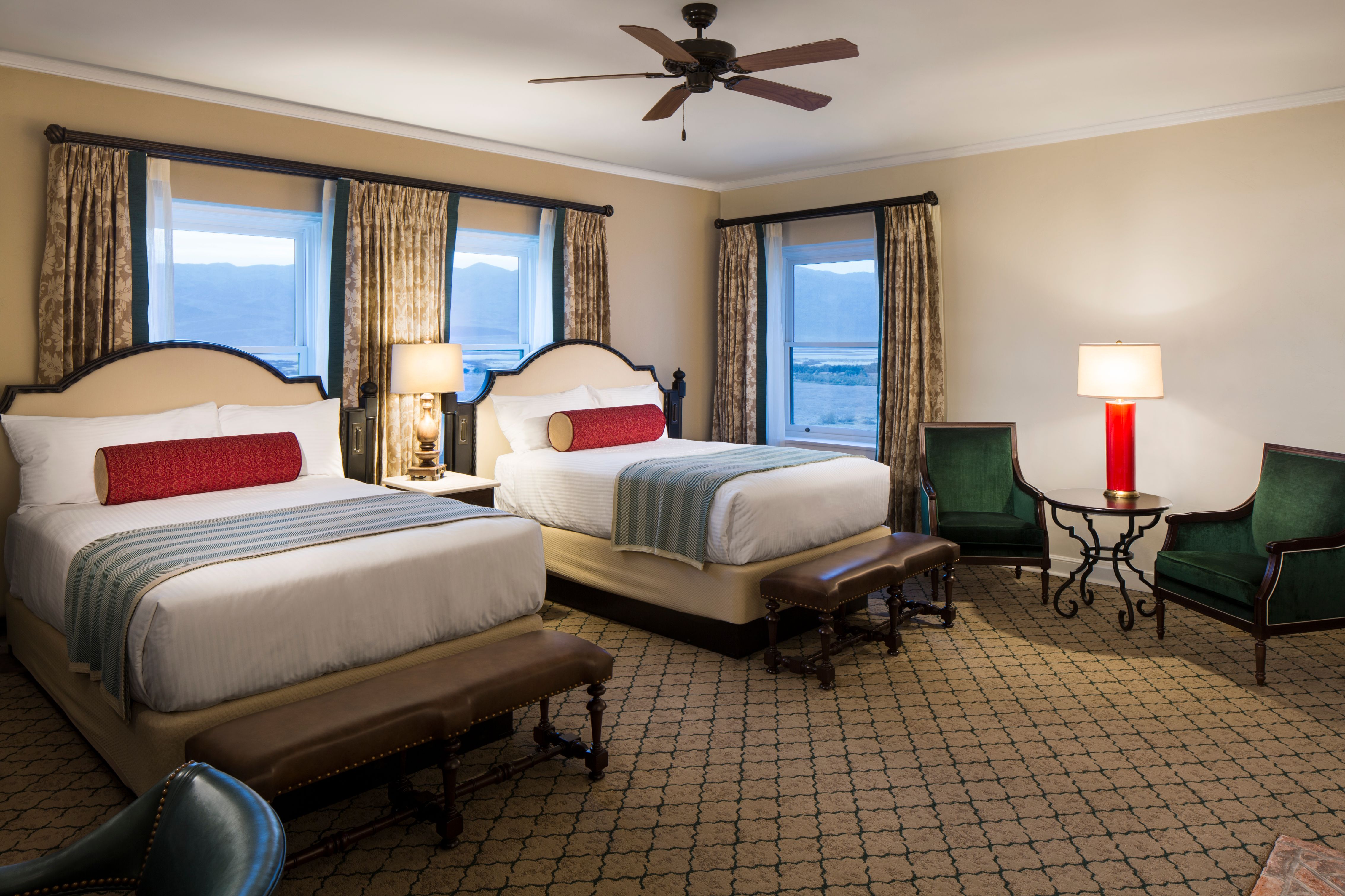 a room with two beds and a fan