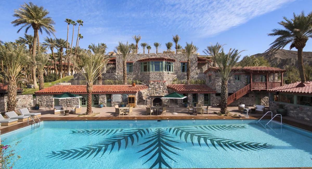 a pool with palm trees in front of a building