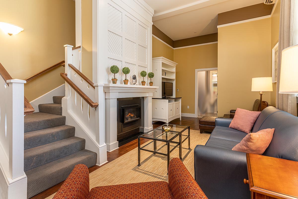 a living room with stairs and a fireplace