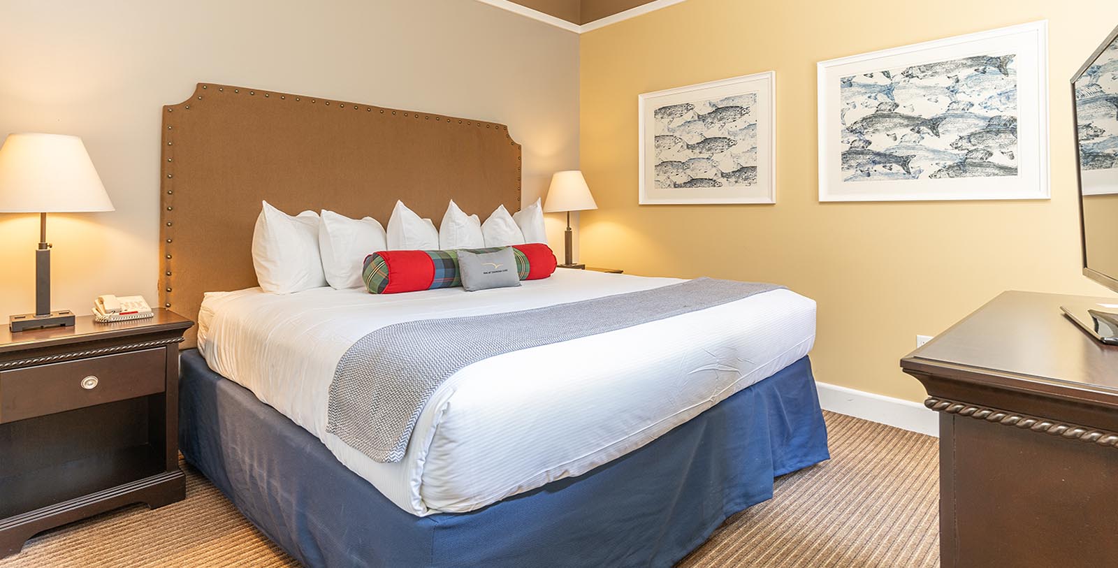 a bed with pillows and a lamp in a room