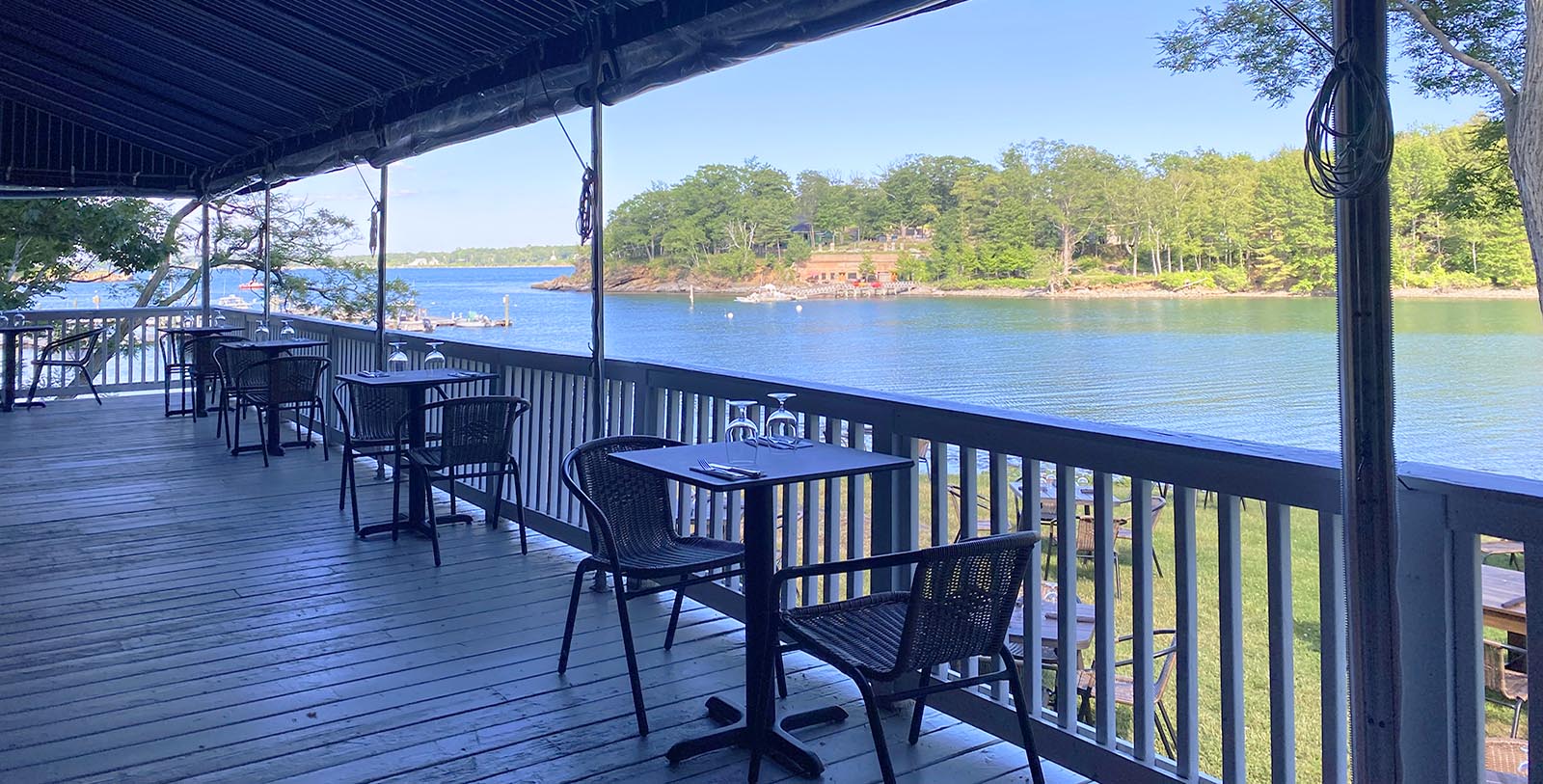 a table and chairs on a deck overlooking a body of water