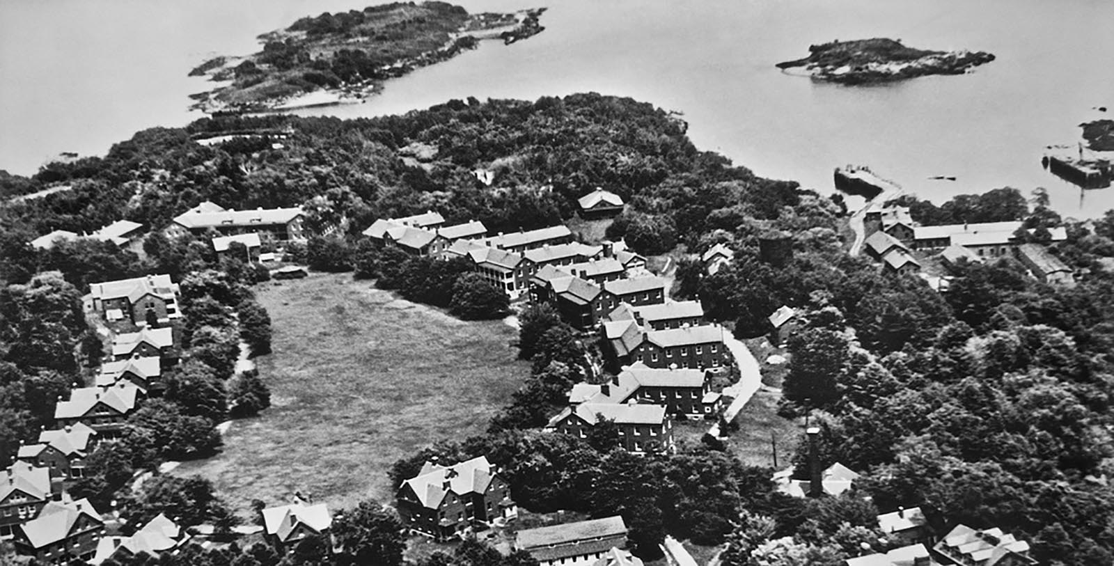 a group of houses surrounded by trees and a river