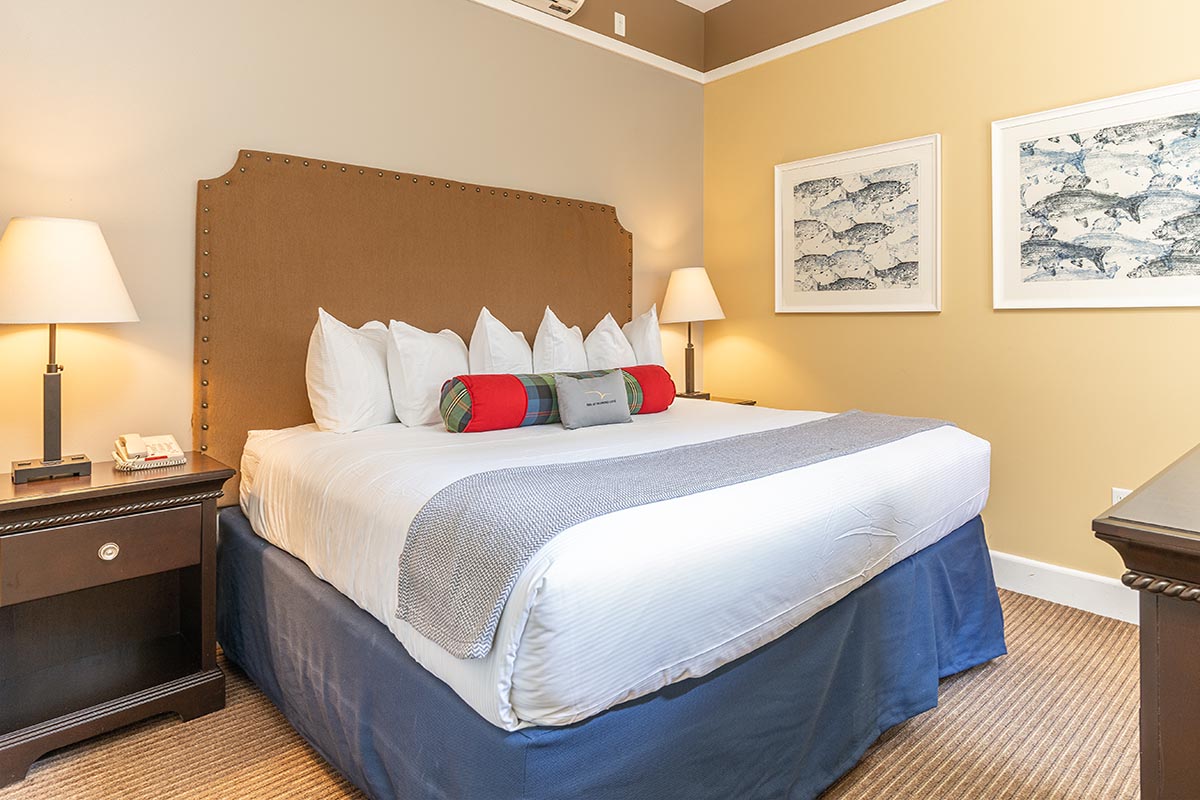 a bed with pillows and a lamp on the side