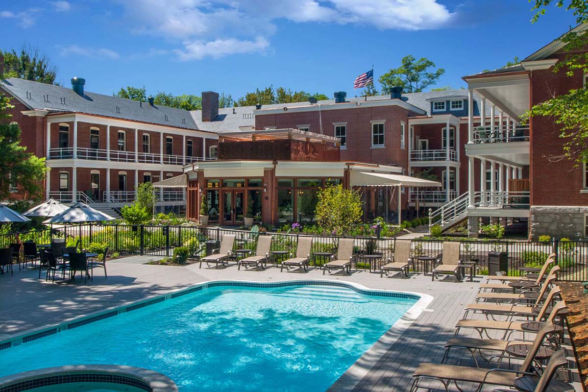 a pool with chairs and a building in the background
