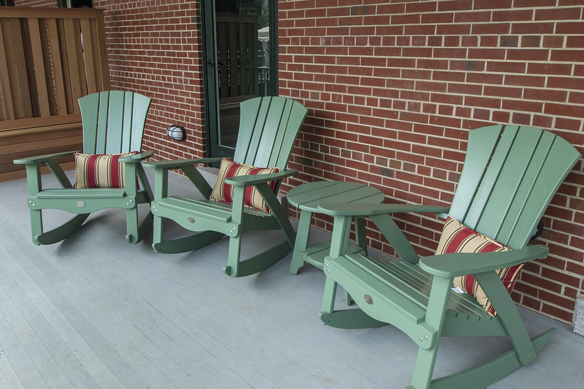 a group of green chairs on a porch