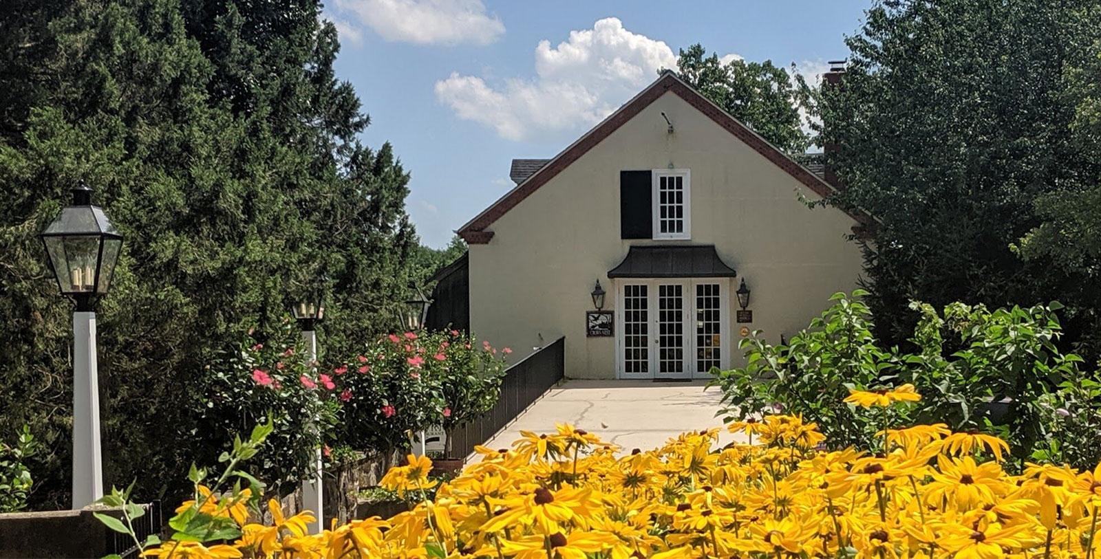 a house with yellow flowers and trees
