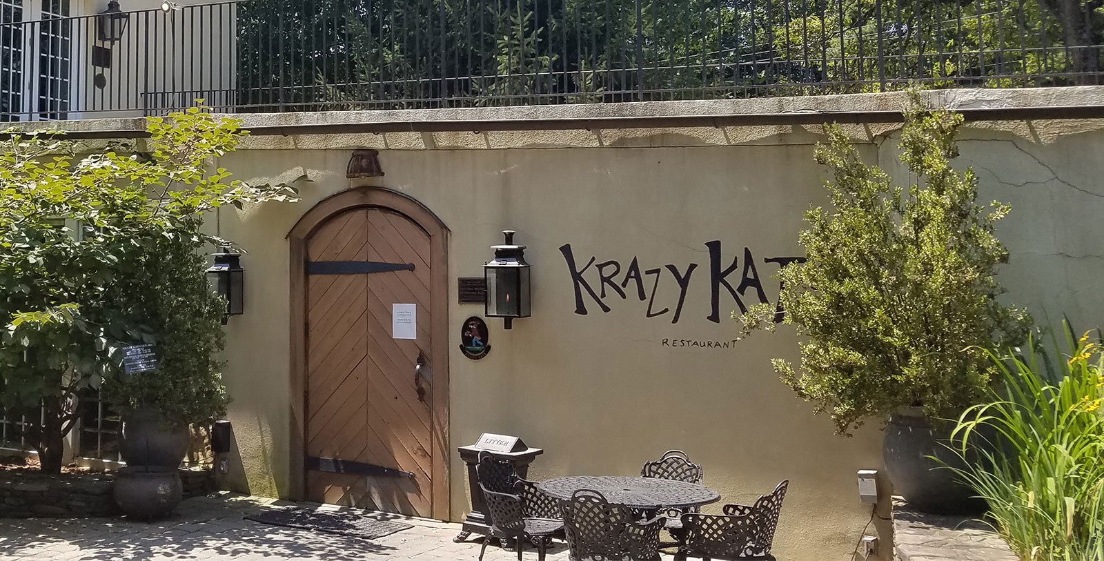 a wall with a door and chairs outside