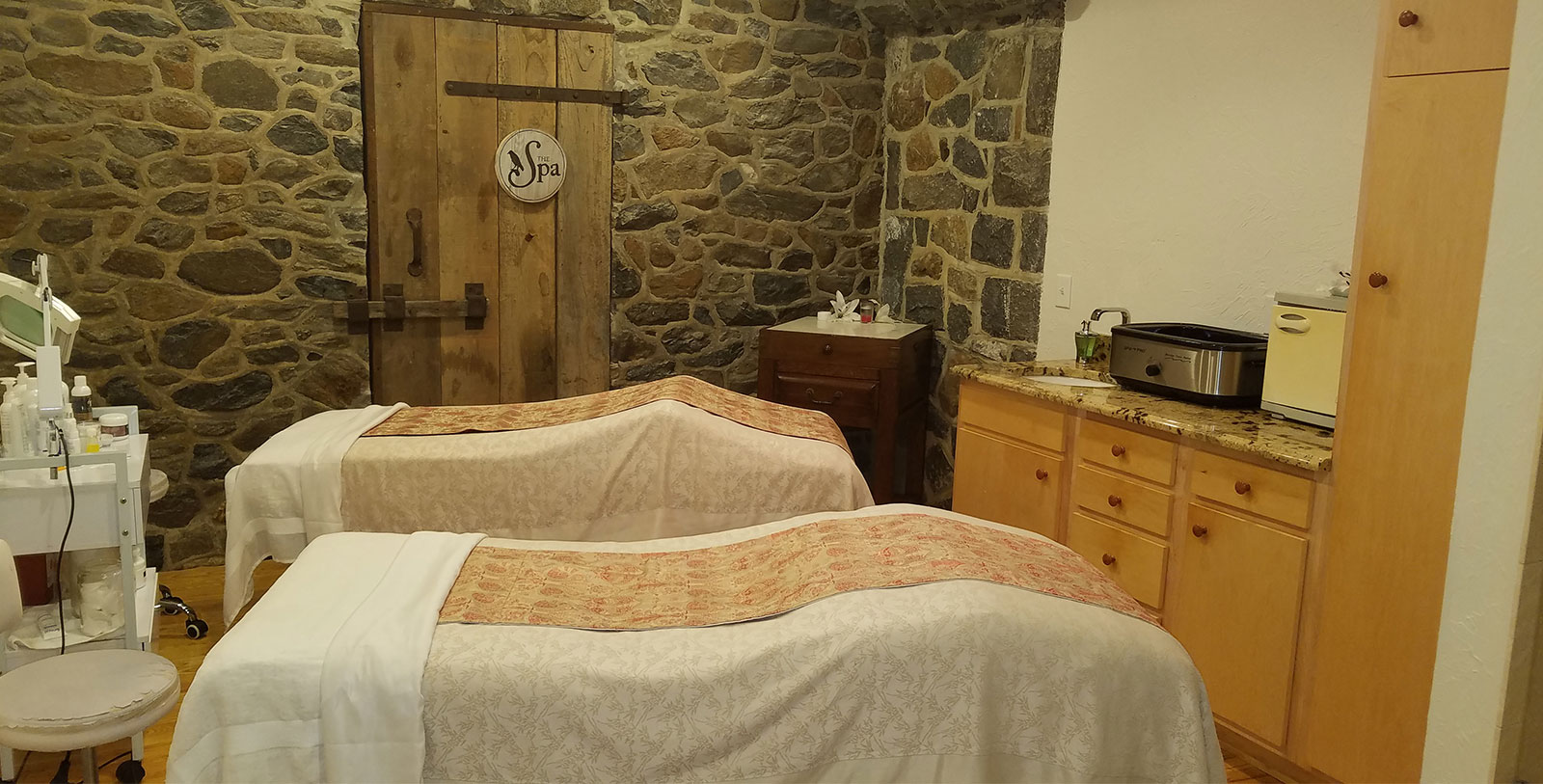 a room with two beds and a stone wall