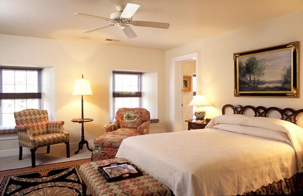 a bedroom with a bed and chairs