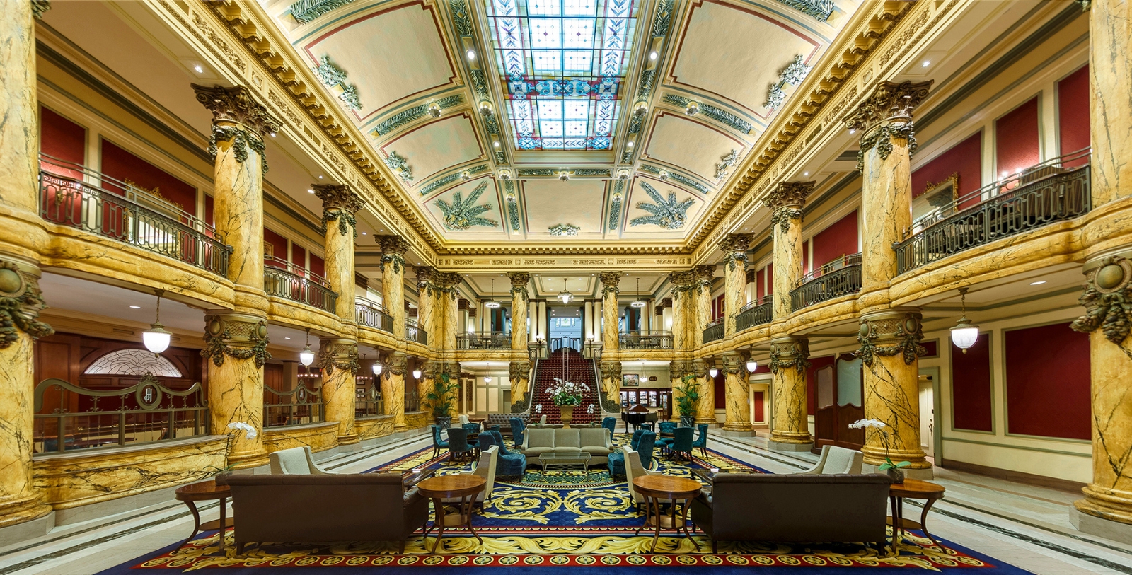 a large room with a staircase and tables and chairs