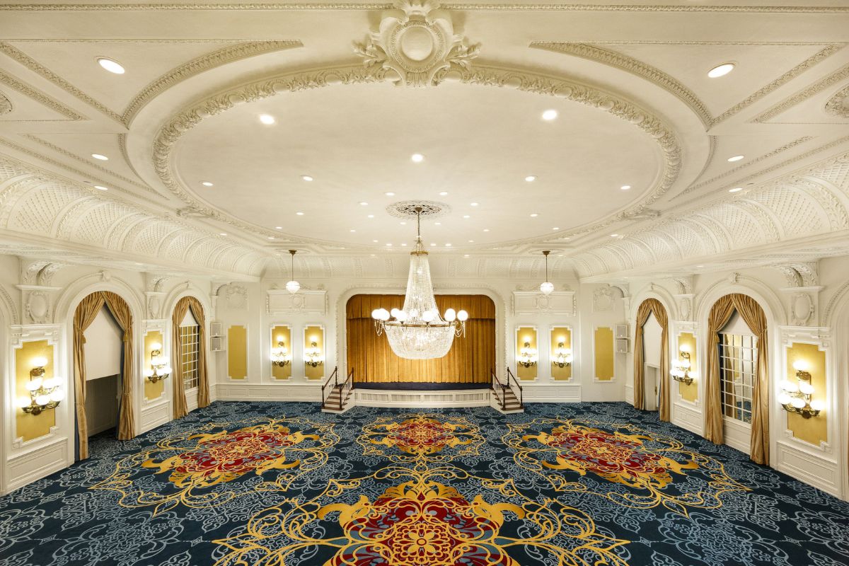 a large room with a chandelier and patterned carpet