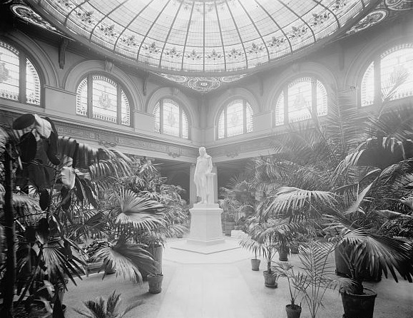a statue in a room with plants