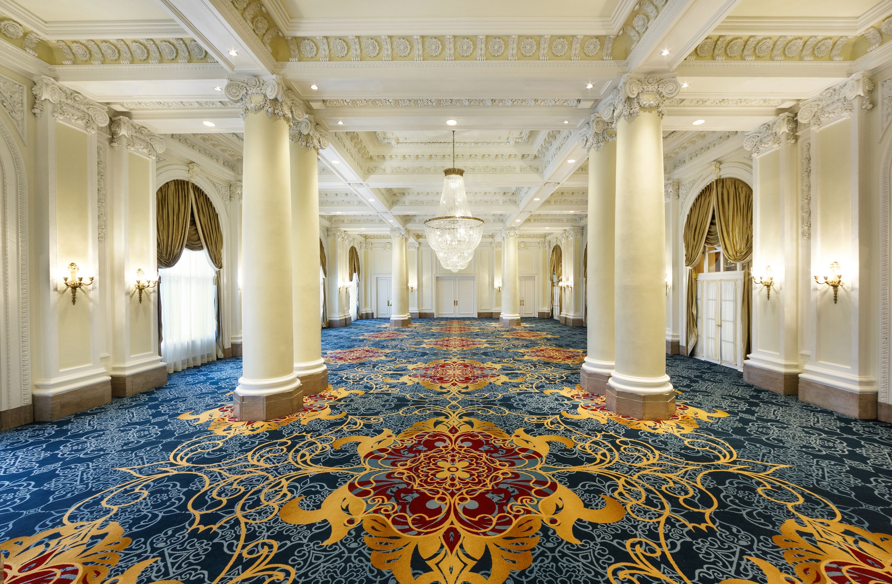 a large room with columns and a chandelier