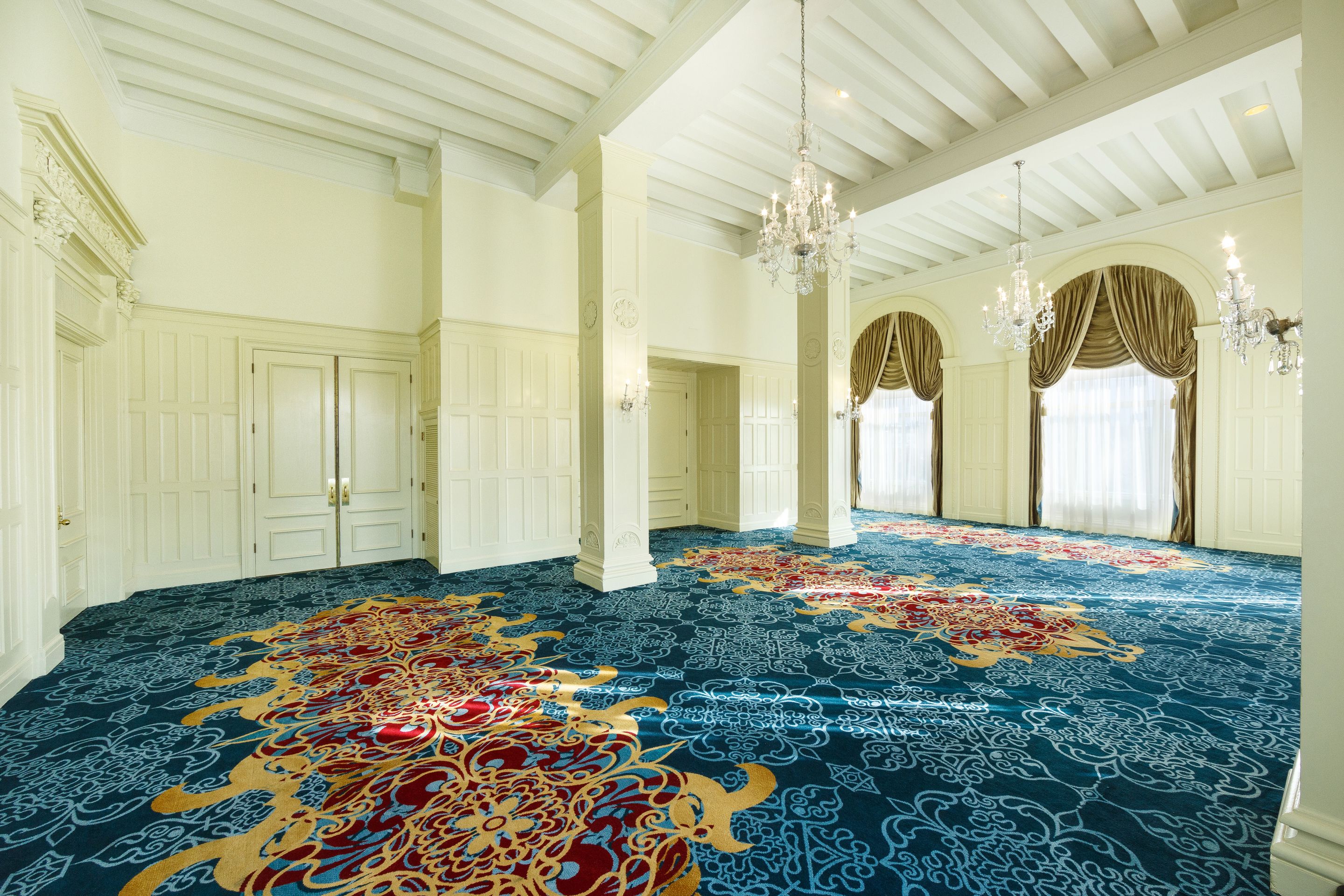 a room with blue carpet and chandeliers