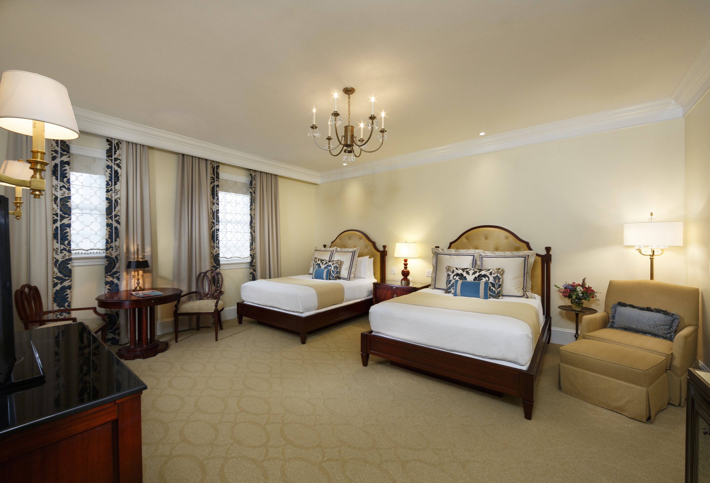 a room with two beds and a chandelier