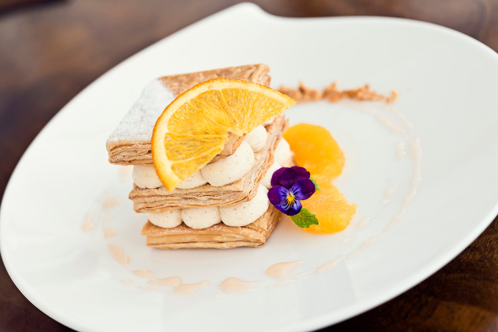 a plate of food with orange slices and a flower