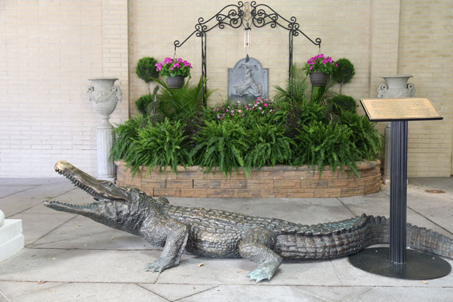 a statue of a crocodile in front of a fountain
