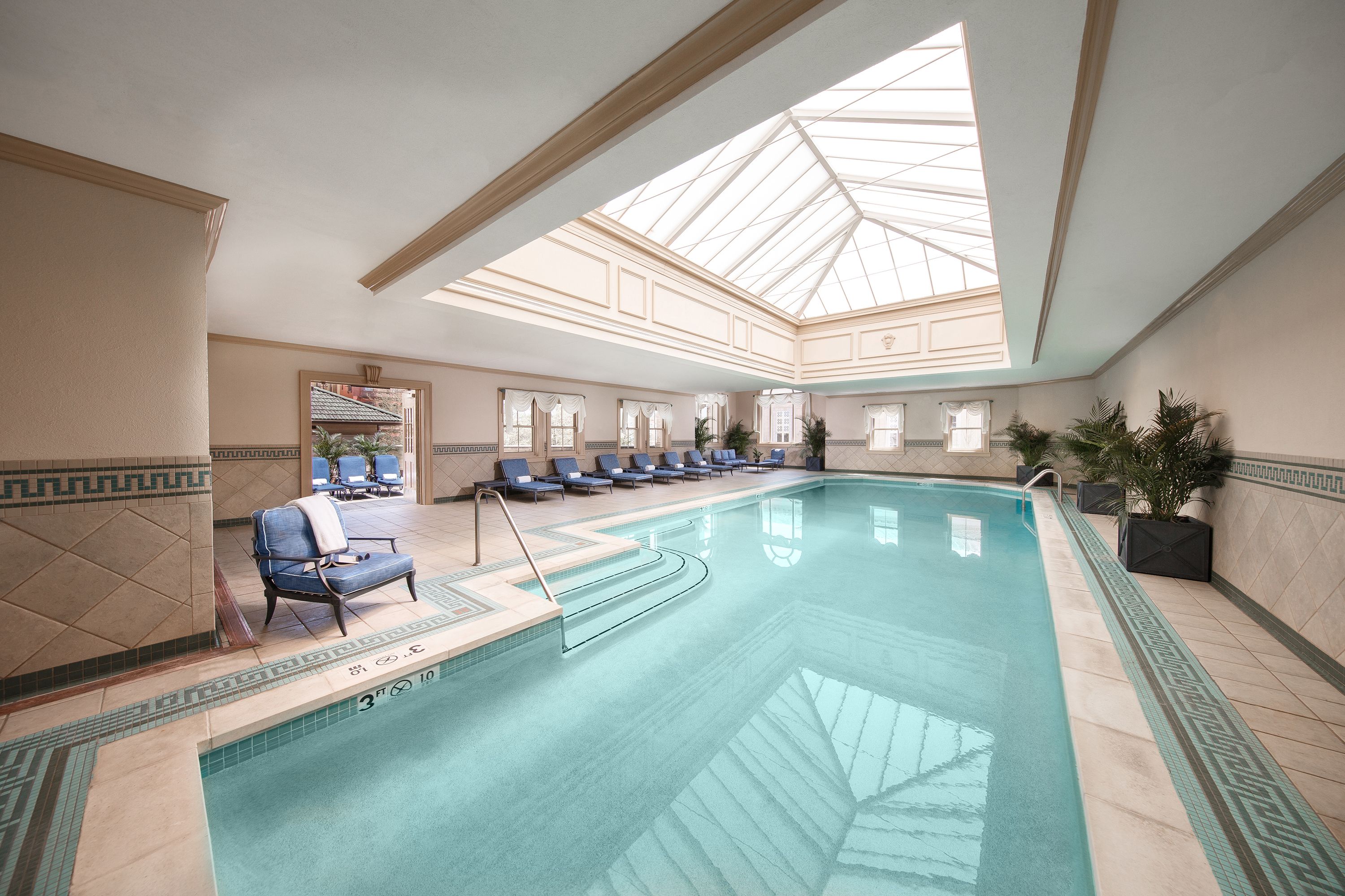 a swimming pool with chairs and a skylight