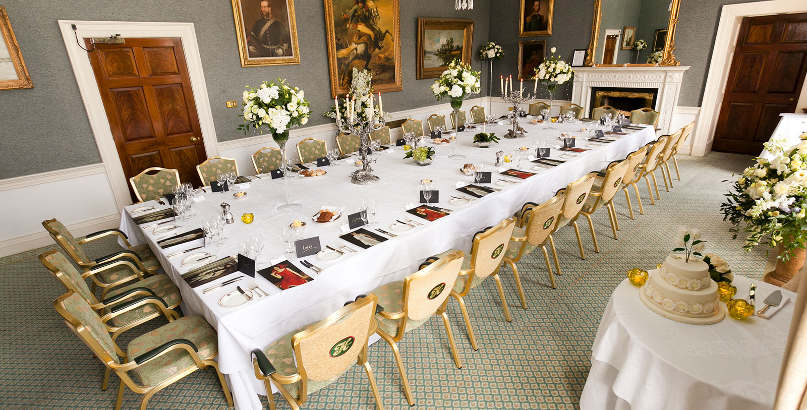 a long table with white tablecloths and candles and flowers