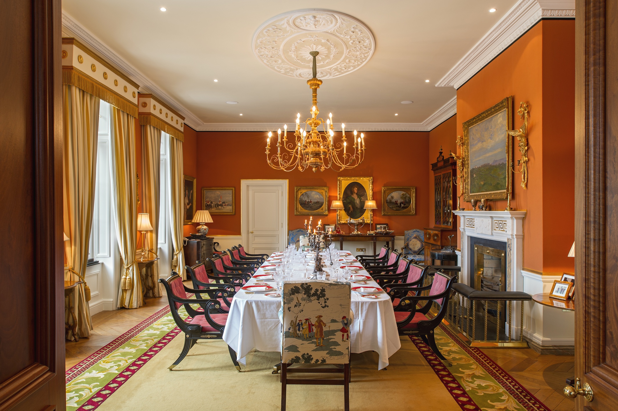 a large room with a large table set with chairs and chandelier