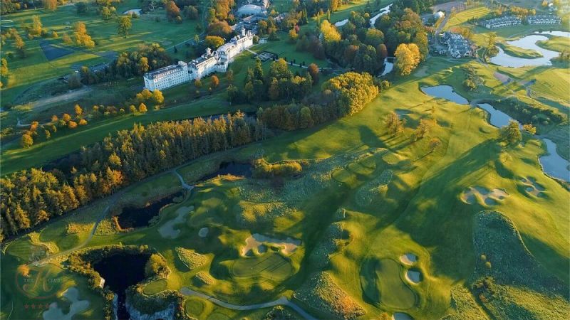 a golf course with a large building and trees