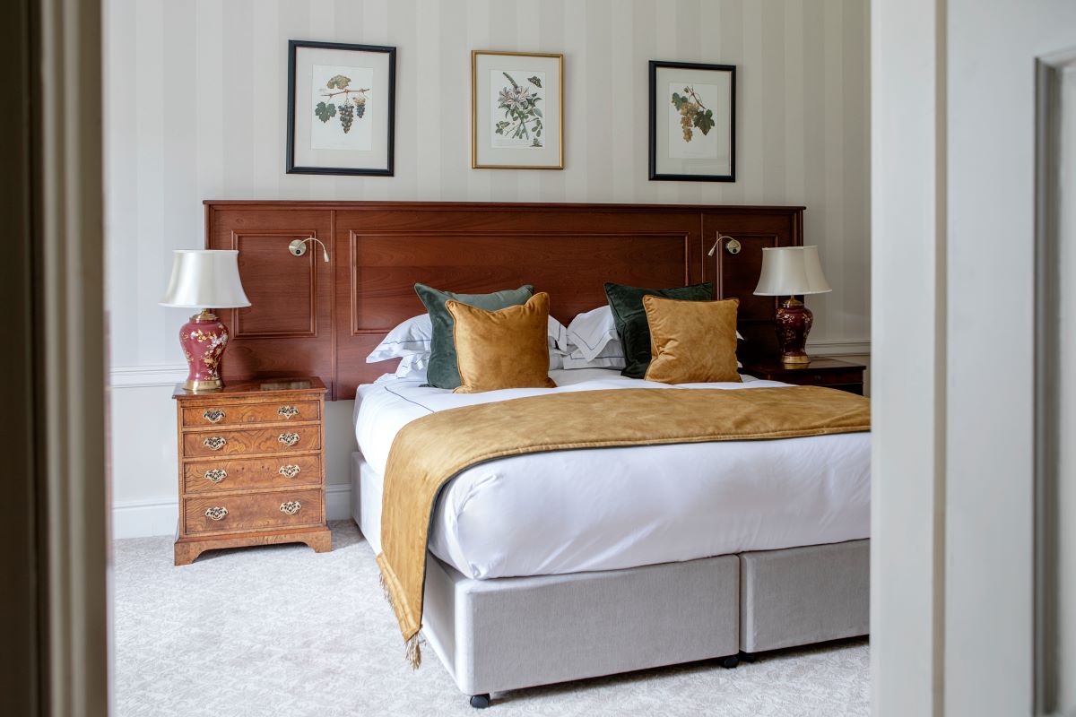 a bed with a wood headboard and lamps