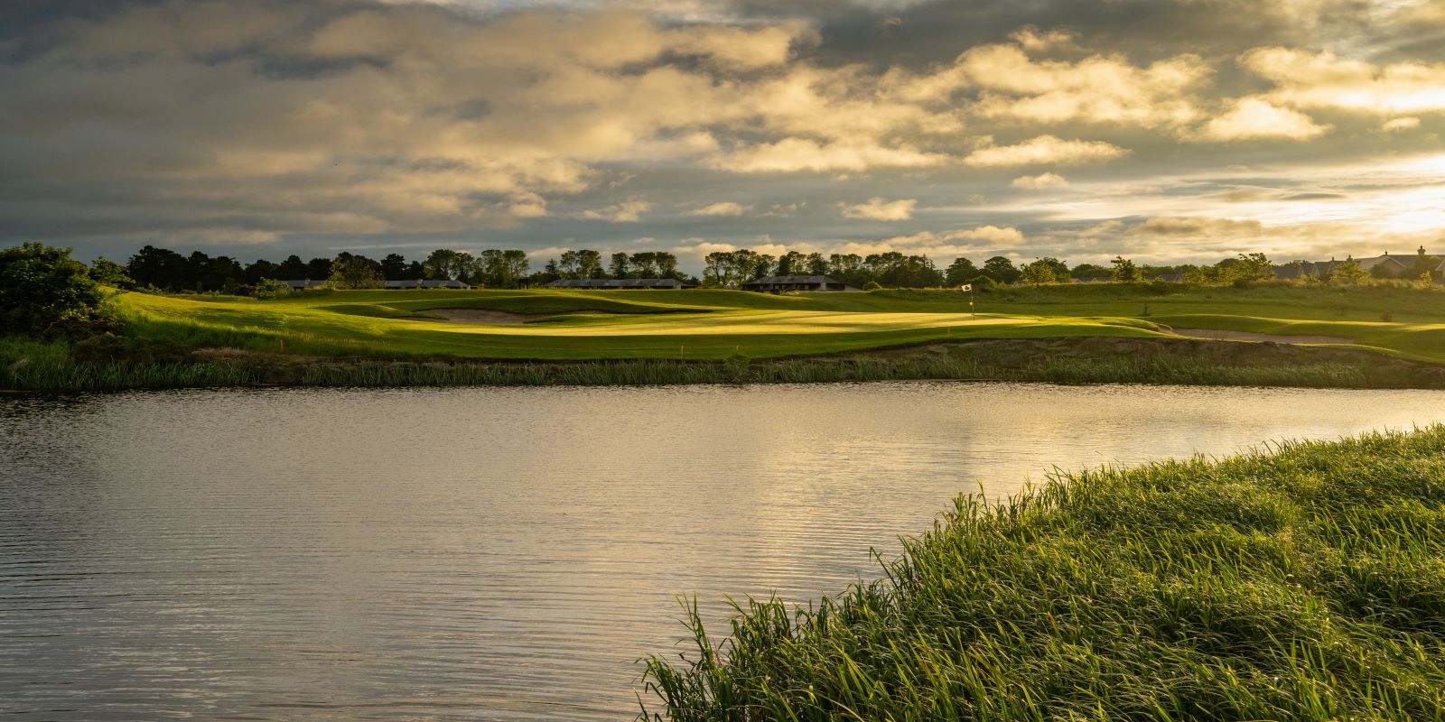 a golf course with a lake and grass