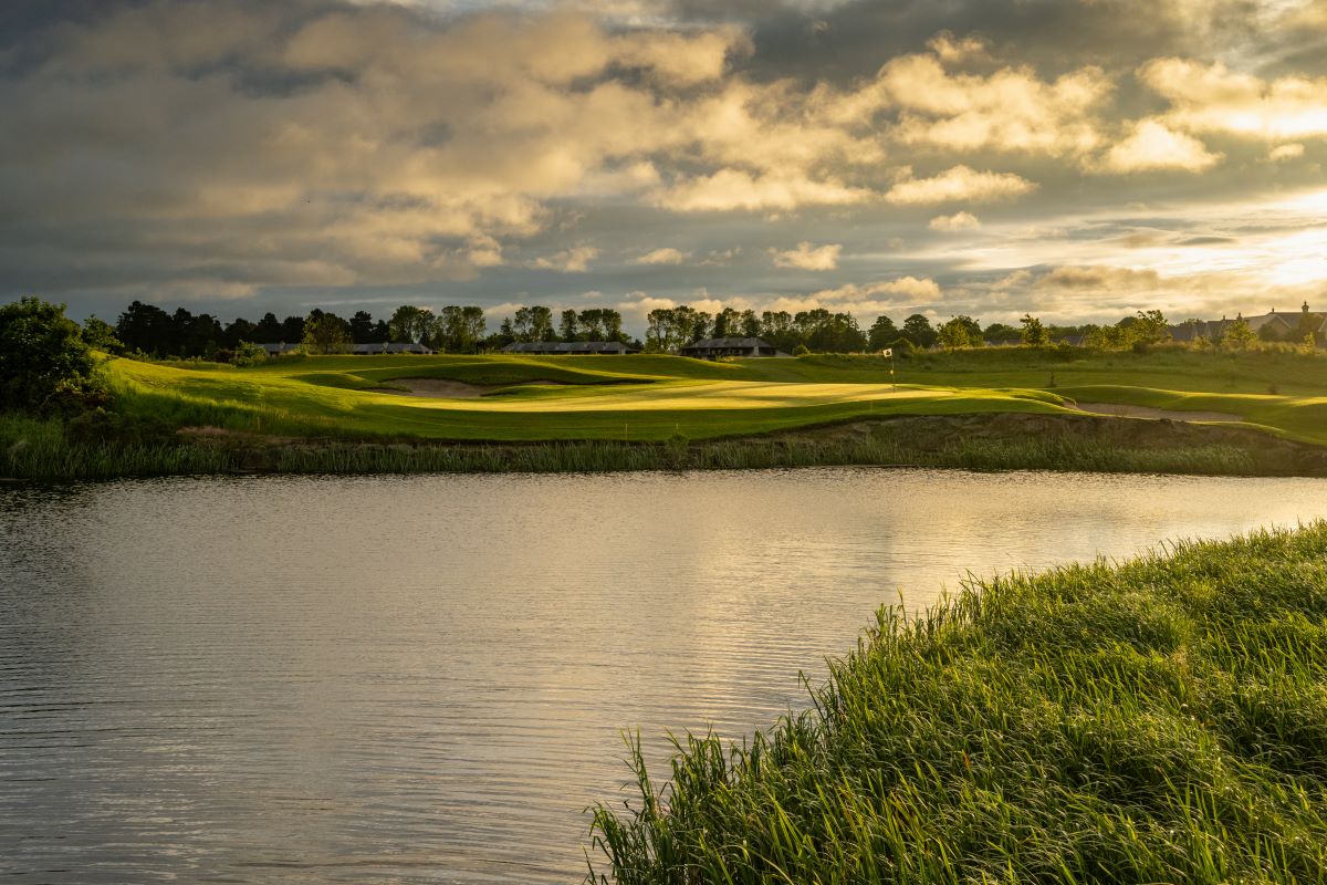 a golf course with a lake and grass