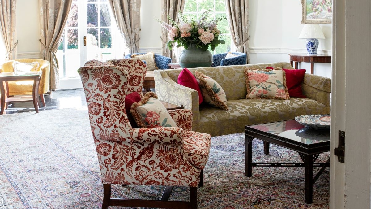 a living room with couches and a vase of flowers