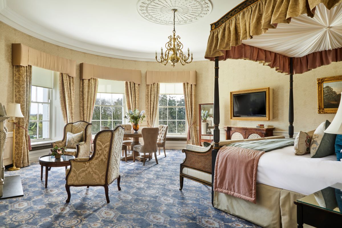 a room with a bed and chairs