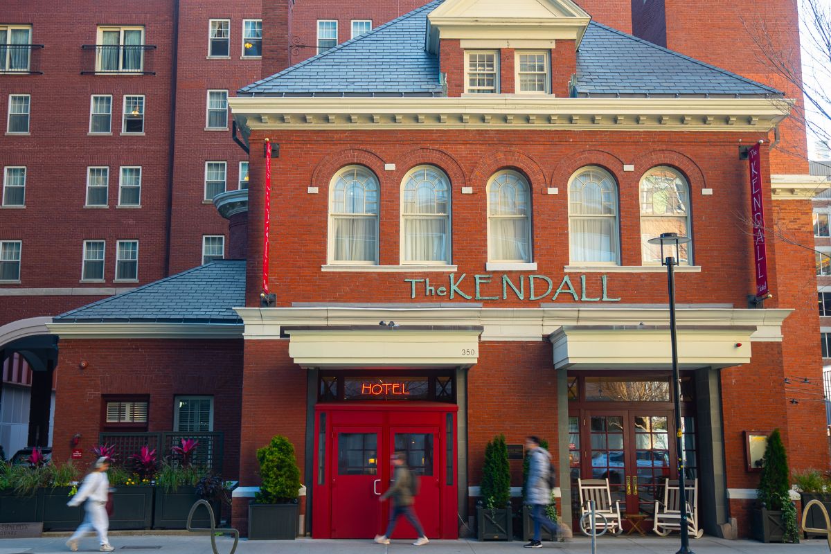 a building with a red door and people walking in front of it