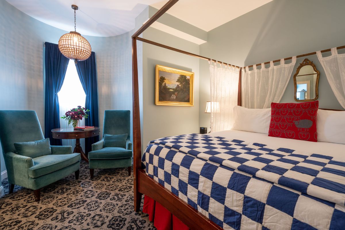 a bedroom with a four poster bed and a chair