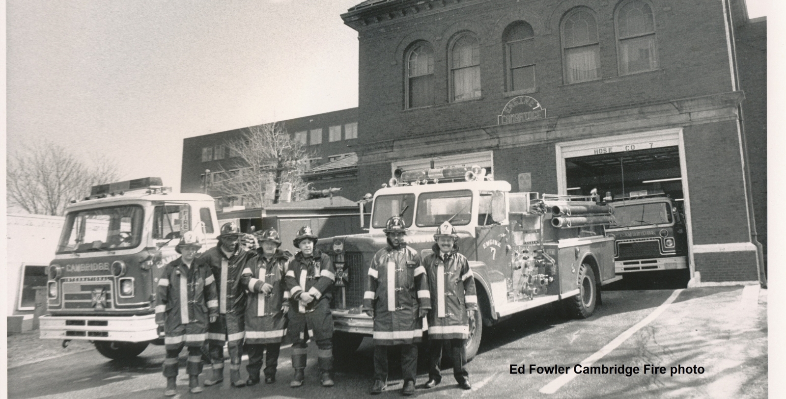 a group of firefighters standing in front of a fire truck