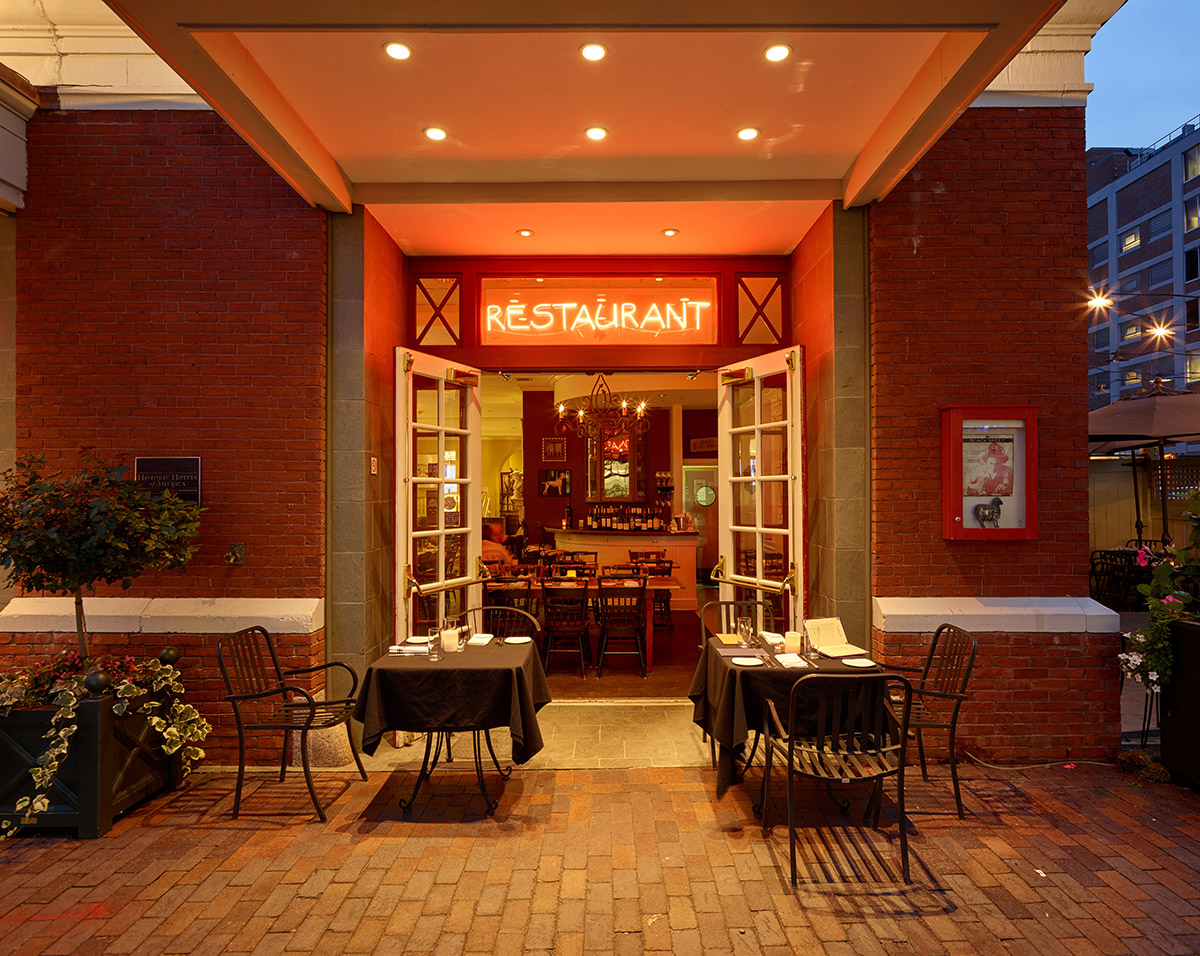 a restaurant with tables and chairs in front of a brick building