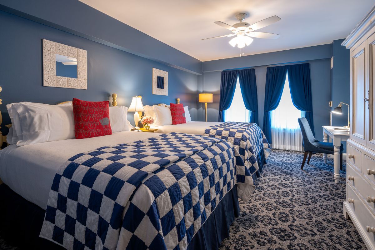 a room with two beds and a fan