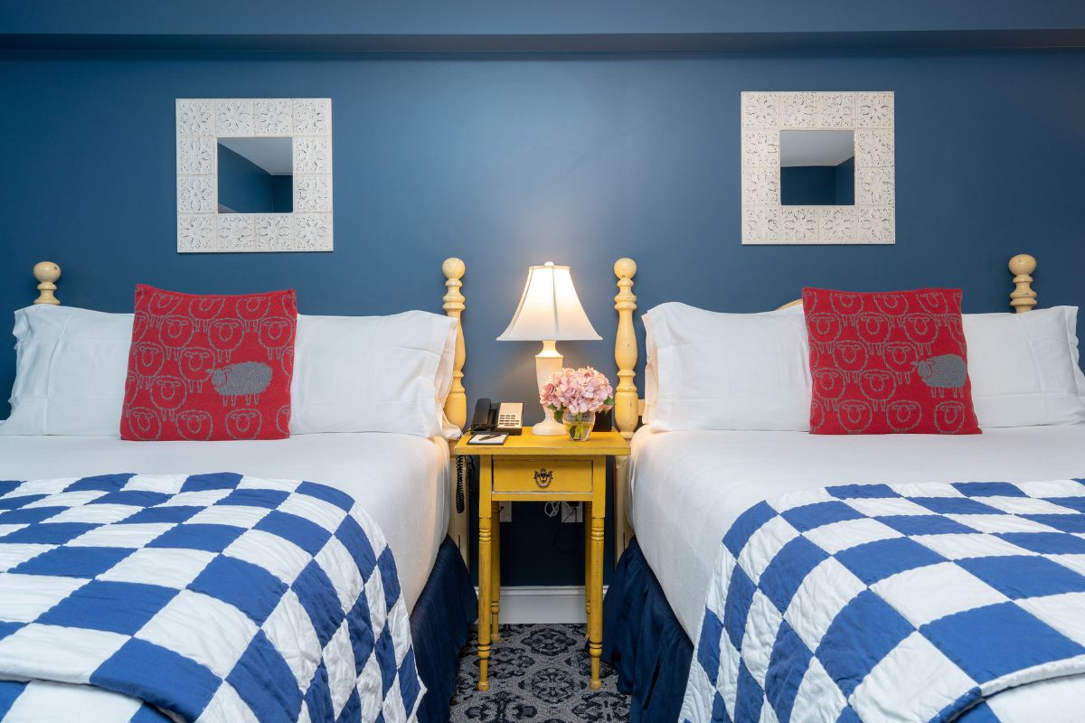 two beds with red and white pillows