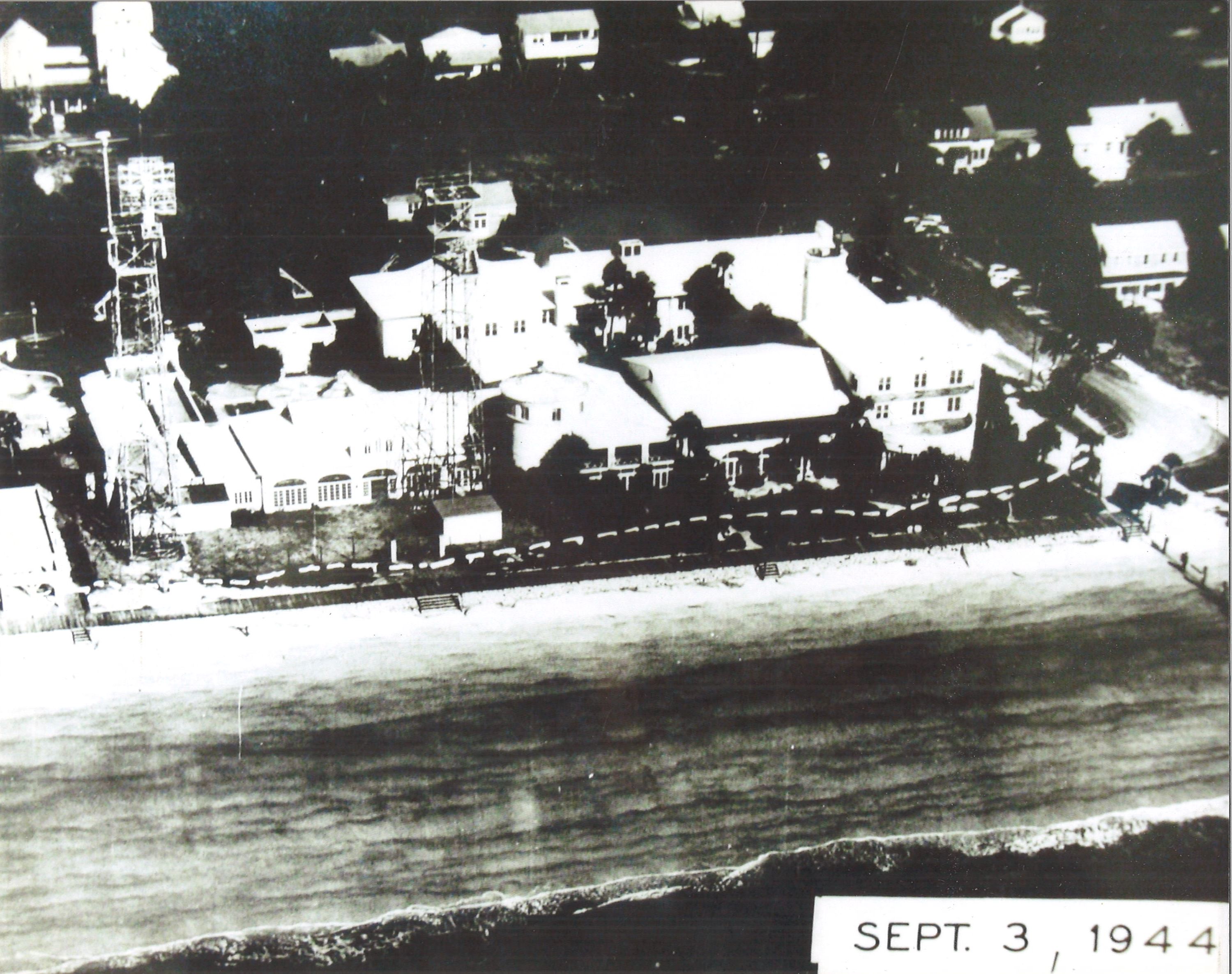 a black and white photo of a beach with buildings