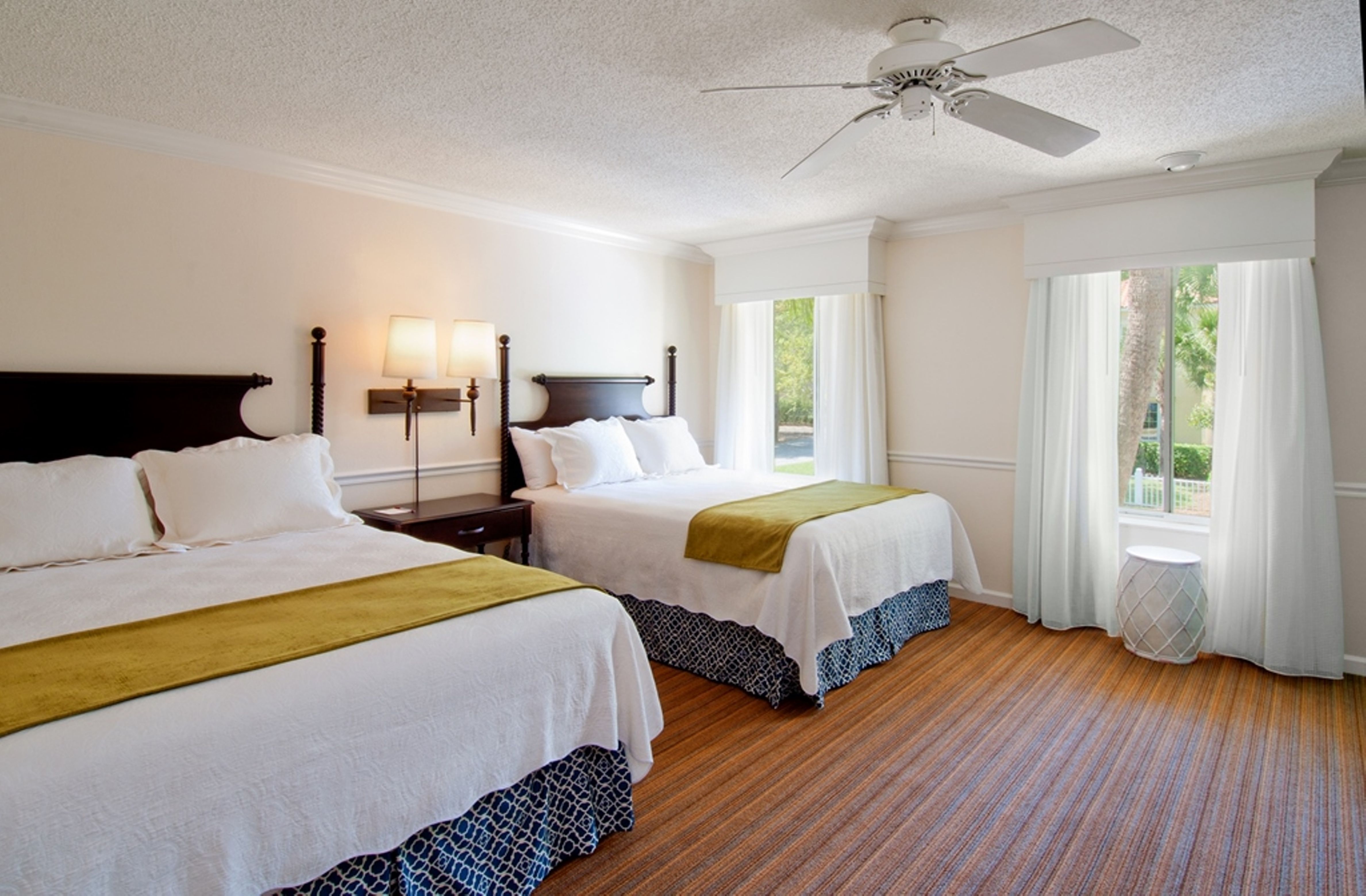 a room with two beds and a ceiling fan