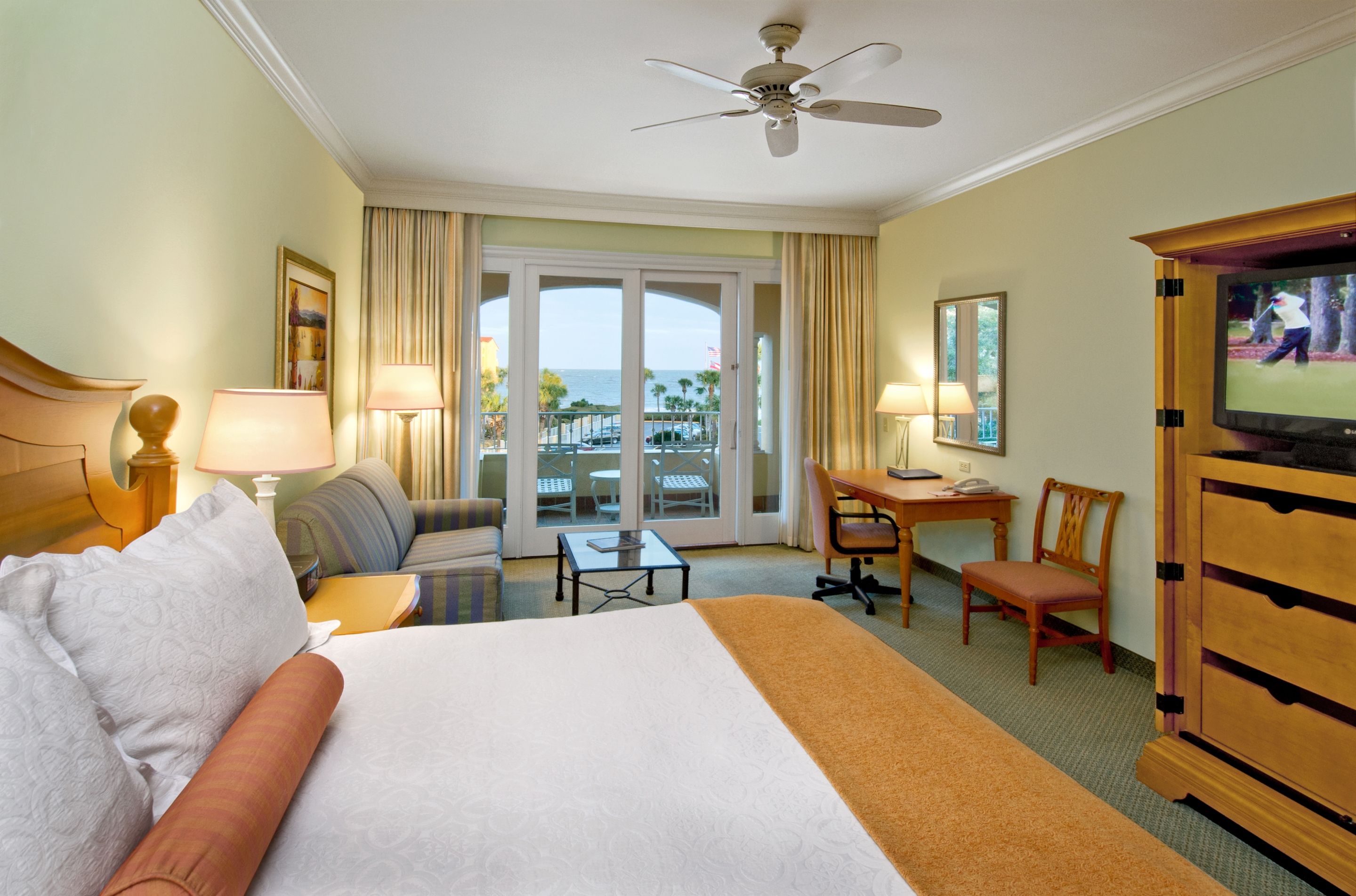 a room with a bed and a desk and chairs